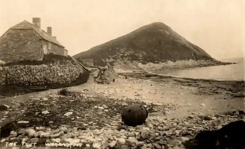 Historical photograph of Worbarrow Tout with Sea Cottage and fishing boats on the beach