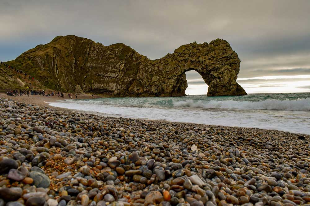 pebbled beach with durdle door in the background